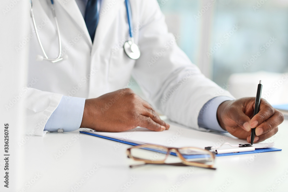 Fototapeta premium Male African-American doctor working in clinic, closeup