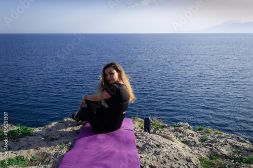 Beautiful young happy lonely girl watching the Mediterranean sea and relaxing