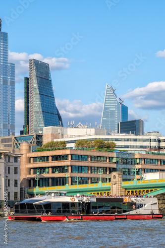 Catamaran under Southwark Bridge on the river Thames in London