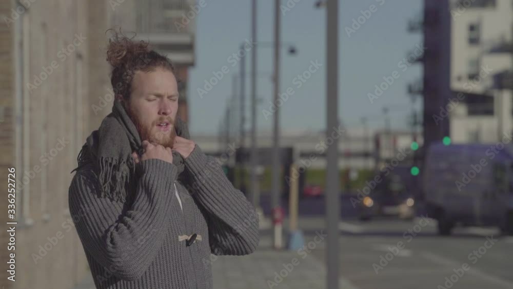 Man wearing scarf standing on the street breathing deeply. Person in an urban city. Man wearing scarf standing on the street breathing deeply. Person in an urban city.