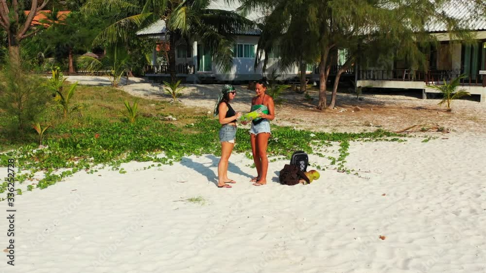 Young women preparing to travel on exotic beaches of tropical island with beautiful shoreline full of lush vegetation in Thailand Young women preparing to travel on exotic beaches of tropical island with beautiful shoreline full of lush vegetation in Thailand