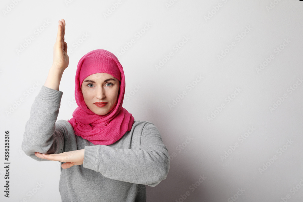 Close-up portrait of a muslim young woman wearing a hijab and putting hand up. Human rights concept. Close-up portrait of a muslim young woman wearing a hijab and putting hand up. Human rights concept.