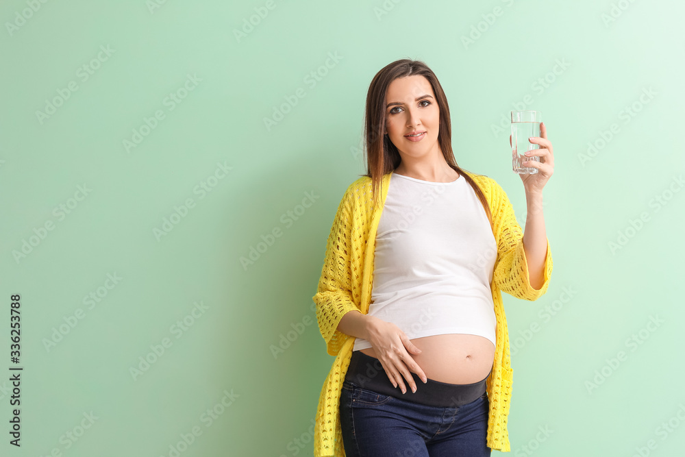 Beautiful pregnant woman with glass of water on color background Beautiful pregnant woman with glass of water on color background