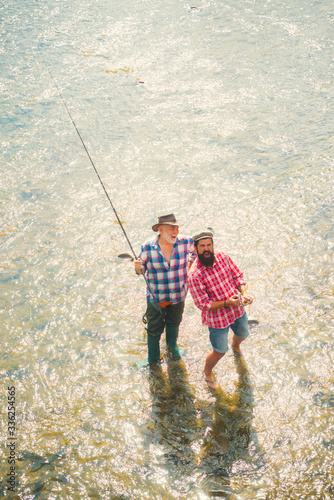 Happy bearded fishers in water. Friends fishing. Successful fly fishing. Big game fishing. Retirement fishery. Family day. Fly fish hobby of men. Activity and hobby.