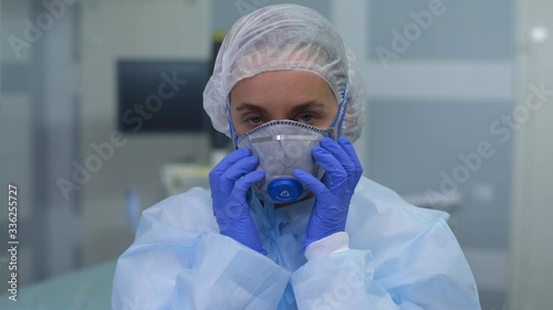 FeMale doctor in protective clothes  and mask during coronavirus pandemic looking at camera. Healthcare and medicine concept
