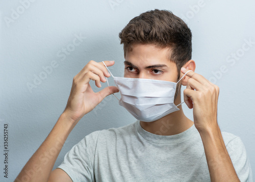 Young hispanic man wearing protection face mask against coronavirus concept