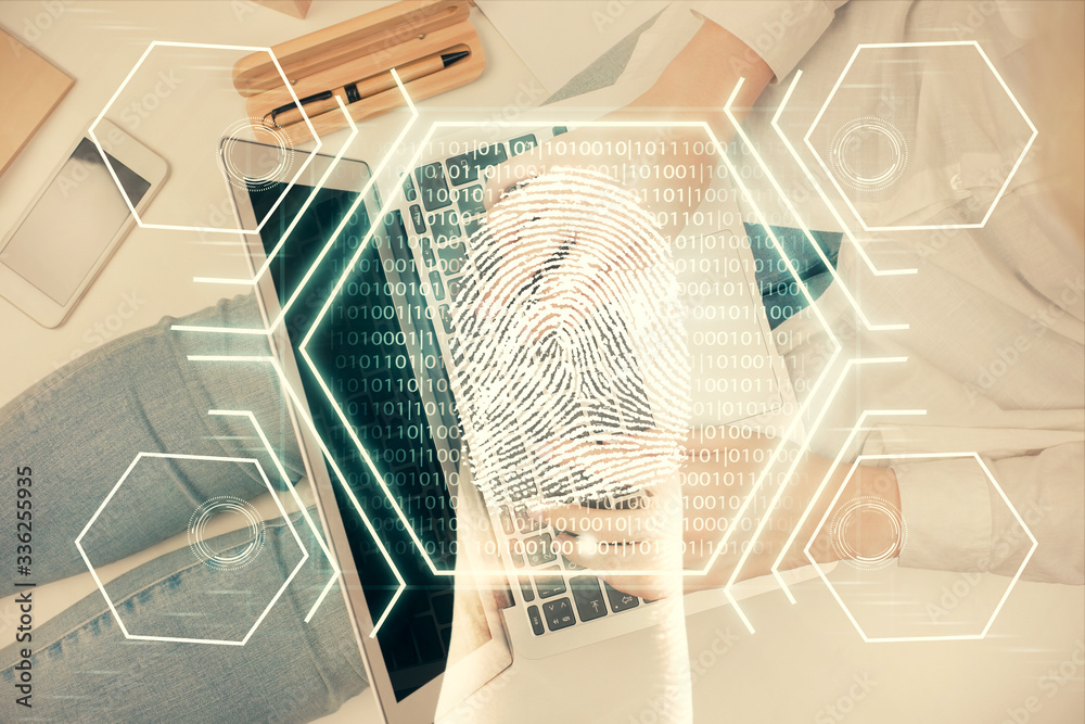 Fototapeta premium Double exposure of woman hands working on computer and fingerprint hologram drawing. Top View. Digital Security concept.
