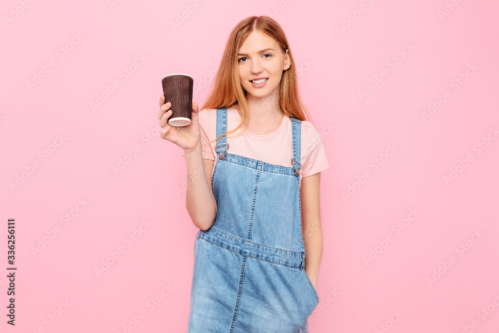 stylish young woman in casual clothes, posing with coffee in hand, on an isolated pink background stylish young woman in casual clothes, posing with coffee in hand, on an isolated pink background