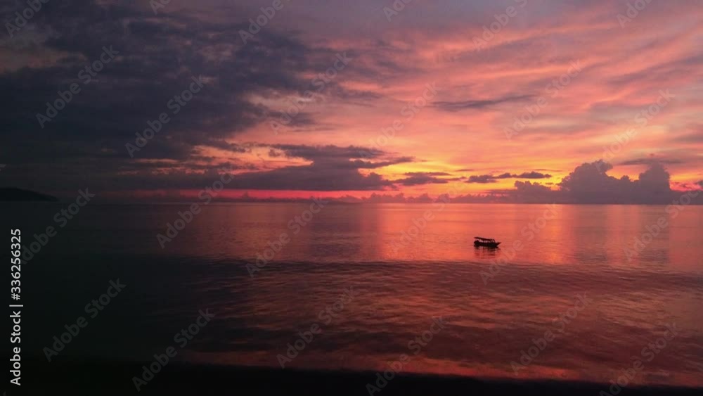 a tropical sunset filmed from above with the drone. An orange sky full of clouds. The rays of the sunset are reflected in the water and the waves of the ocean. a tropical sunset filmed from above with the drone. An orange sky full of clouds. The rays of the sunset are reflected in the water and the waves of the ocean.