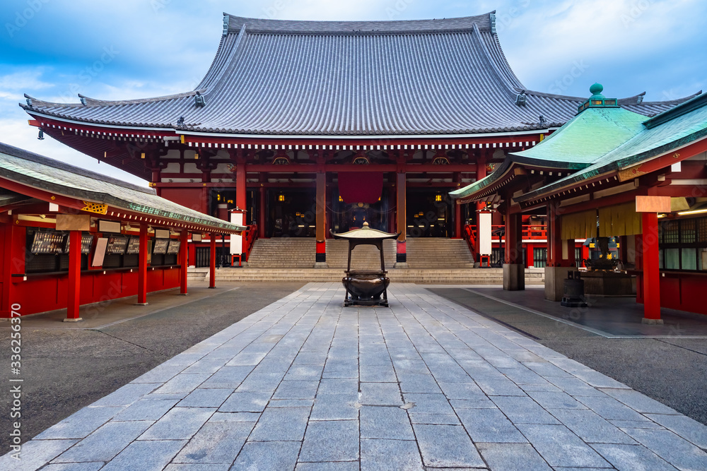Japan. Sensoji in Tokyo. Asakusa Temple. Buddhist temple in sunny weather. Cauldron for washing hands. The temple of the three deities on the background of blue sky. Excursions to the Asakusa Temple