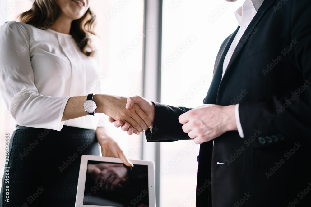 Unrecognizable office worker shaking hands with faceless entrepreneur