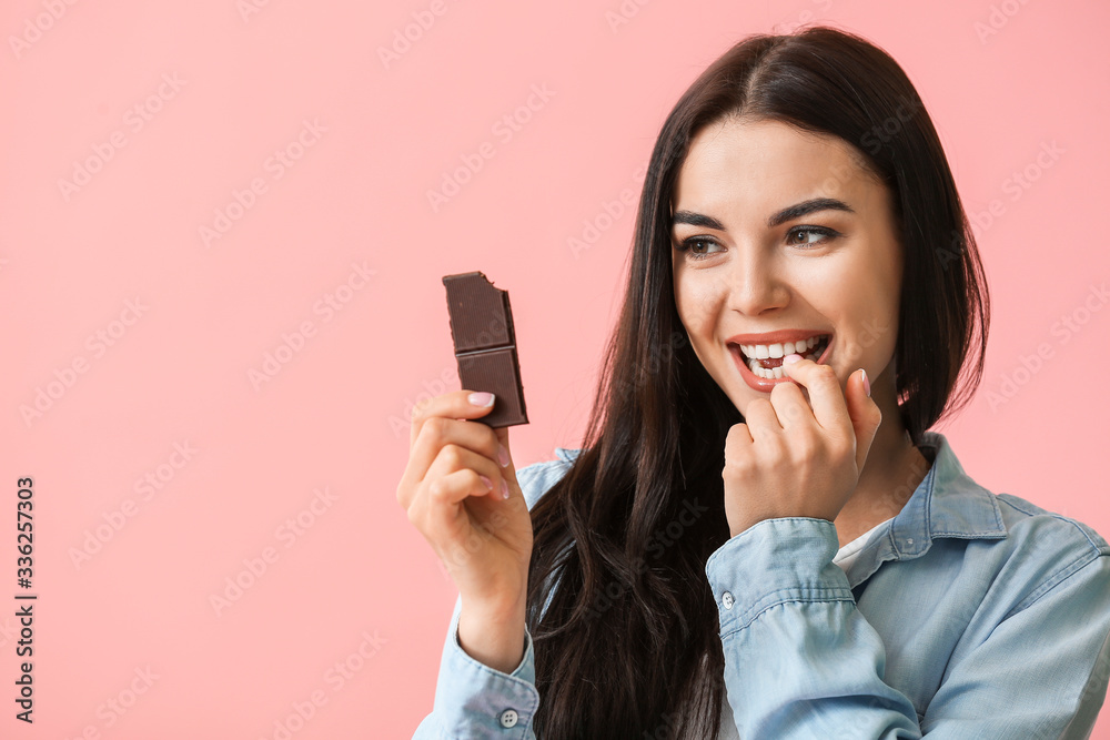 Beautiful young woman with chocolate on color background Beautiful young woman with chocolate on color background