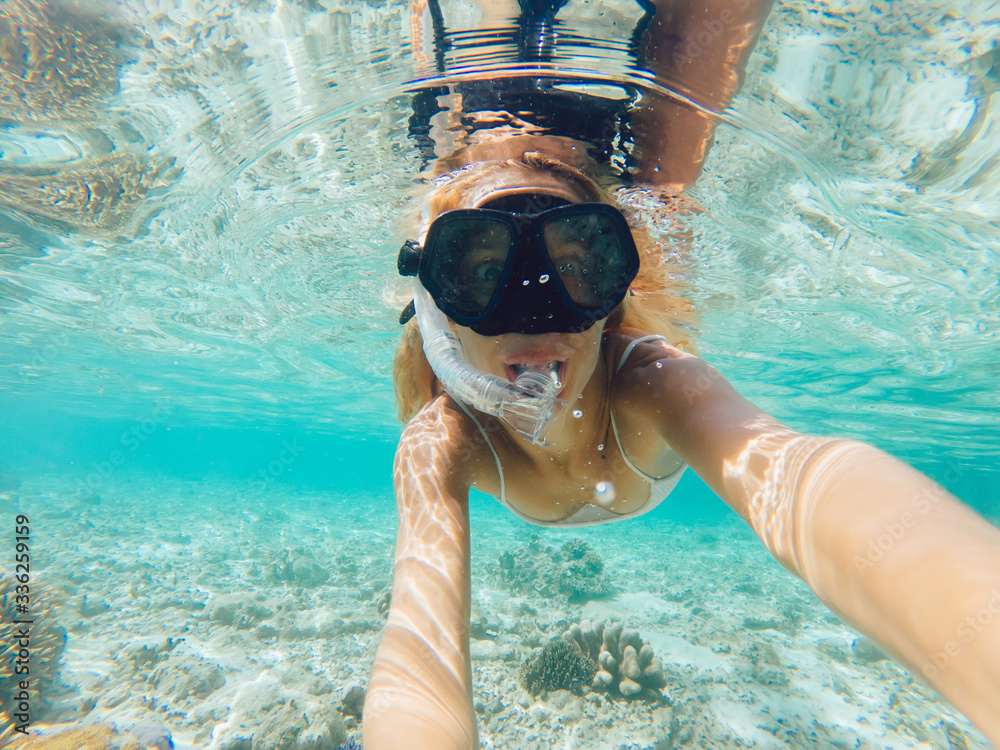 Young smiling blonde taking selfie underwater - obrazy, fototapety, plakaty 