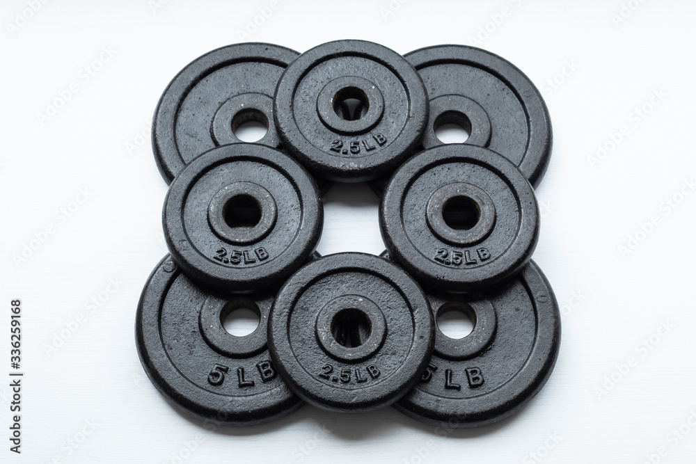 Closeup to a dumbbell disc over white background. Ideal for fitness, sports, and healthy life. Closeup to a dumbbell disc over white background. Ideal for fitness, sports, and healthy life.