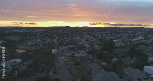 Hollywood style aerial video shot filmed in Cinematic 4K of a vibrant sunset over a small beach town