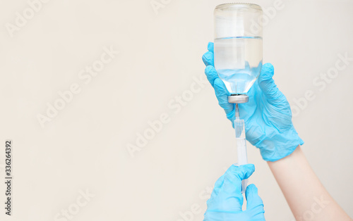 a doctor or nurse in rubber gloves prepares a close-up injection. Saline solution of sodium chloride. Isotonic solution. Copy space  space for text