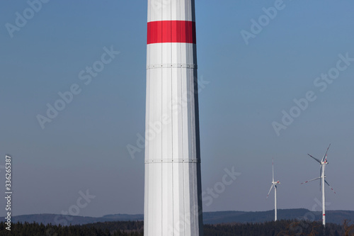 modern wind turbine column in front of the evening sun