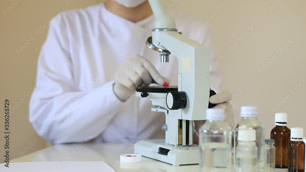 Scientist looks at medical samples under microscope and says Scientist looks at medical samples under microscope and says