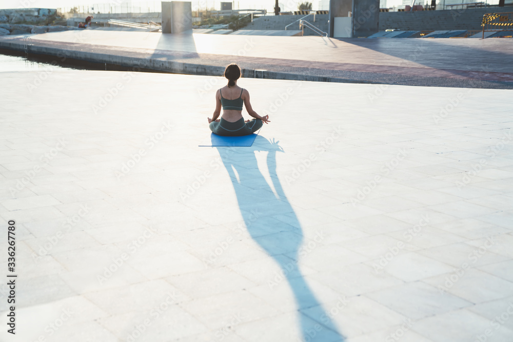 Fototapeta premium Unrecognizable woman sitting in lotus pose