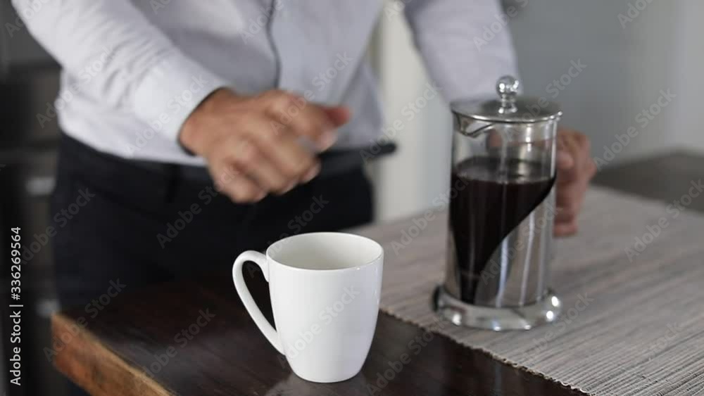 Man making a coffee with french press. Caucasian man pouring coffee in coffee cup at kitchen in a comfortable home. Slow Motion. Man making a coffee with french press. Caucasian man pouring coffee in coffee cup at kitchen in a comfortable home. Slow Motion.