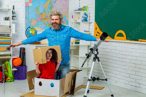 Pupil enjoy time with teacher father and playing with paper rocket. © Volodymyr