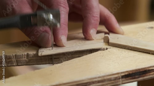 person hands cut brown wooden tail unit planes for vintage passenger aircraft model slow motion extreme closeup