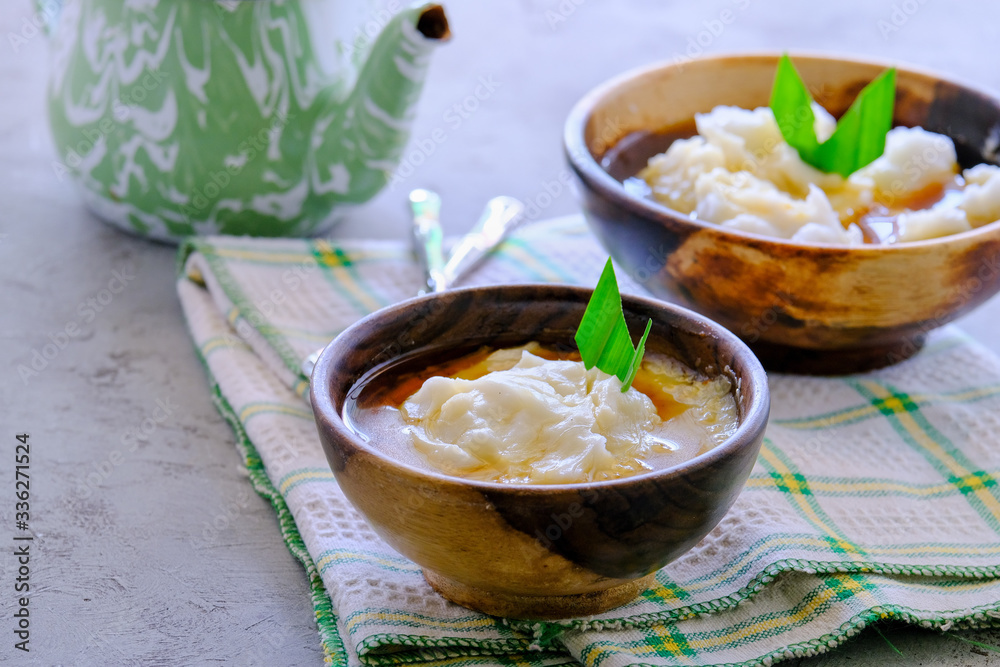 Bubur Sumsum. Javanese dessert porridge of rice flour, coconut milk with palm sugar syrup. Served in an wooden bowl. A popular starter food for breaking the fast during Ramadan. Bubur Sumsum. Javanese dessert porridge of rice flour, coconut milk with palm sugar syrup. Served in an wooden bowl. A popular starter food for breaking the fast during Ramadan.