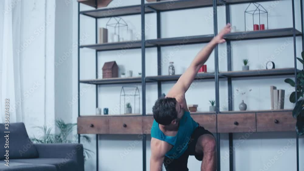 young sportsman exercising in one legged plank pose on floor at home young sportsman exercising in one legged plank pose on floor at home