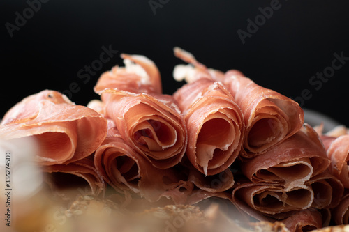 close up of prosciutto and crackers on a charcuterie meat board