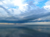 Clouds and rain over the smooth surface of the lake. Lake Sivash, Crimean peninsula.