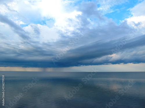 Clouds and rain over the smooth surface of the lake. Lake Sivash, Crimean peninsula.