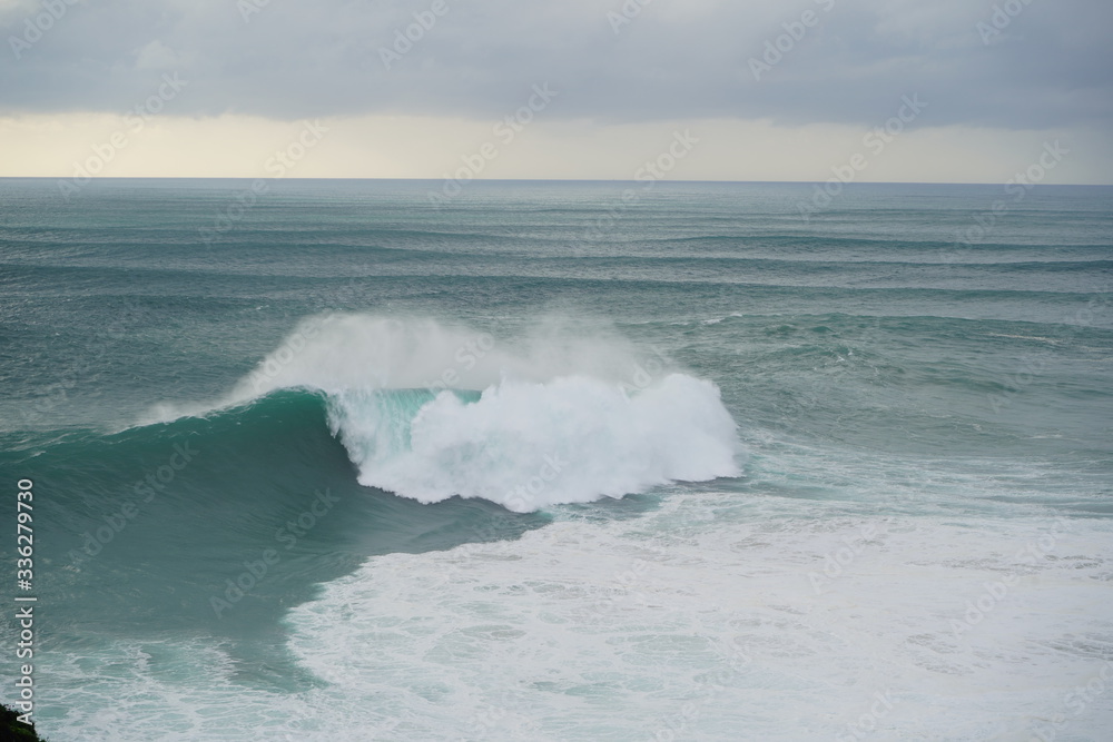 Fototapeta premium Another huge wave in Nazare. Cloudy day in this beautiful town