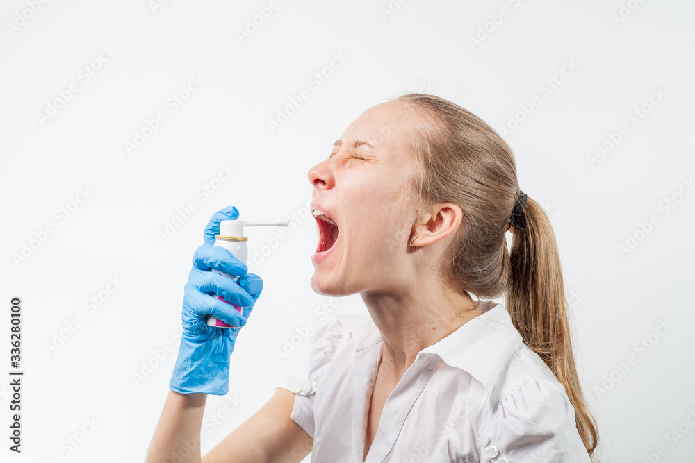 Young doctor uses healing spray to relieve sore throat with sore throat and flu. COVID-19 Young doctor uses healing spray to relieve sore throat with sore throat and flu. COVID-19