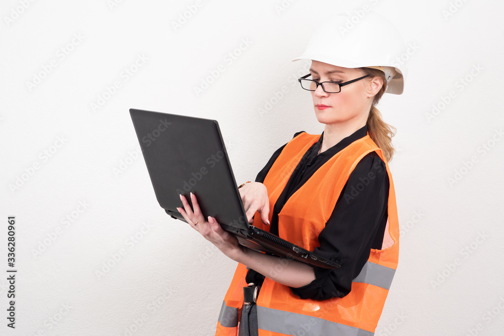 Female engineer. Girl with a laptop in a reflective vest. Girl i