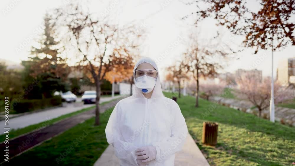 Female physician walking  in uniform on front line,fighting viral outbreak.Private protective equipment (PPE).Quarantined area decontamination. COVID-19 corona virus doctor in hazmat suit.