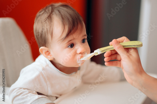 Funny Cute Adorable Baby Eating Yogurt in the Kitchen
