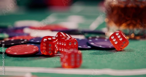Close up of rolling dice in red on a heap of poker chips shot in 4k super slow motion photo