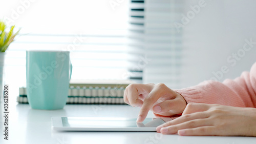 Close up of woman hand using digital tablet at home  People and technology lifestyle  e commerce  online business  e learning  education  lifestyle concept