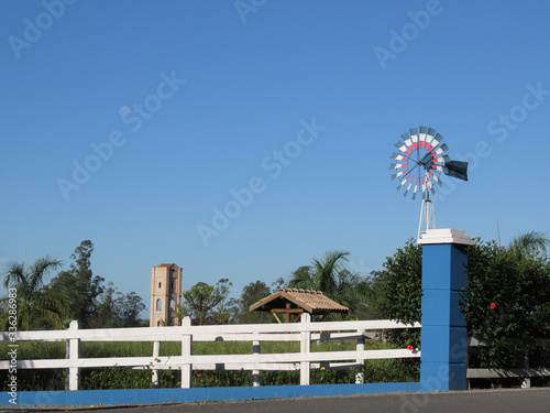 Pinwheel and large tower in the background between wooden fences