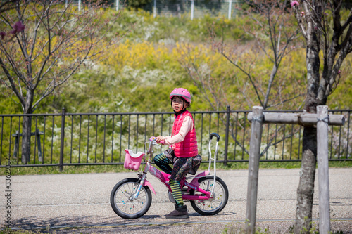 春の公園で自転車を乗っている子供
