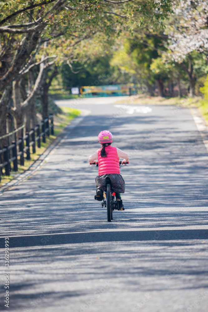 Obraz premium 春の公園で自転車を乗っている子供