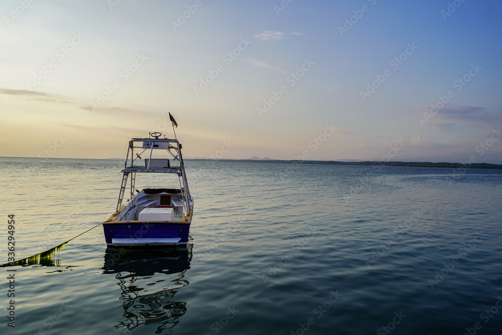 Obraz premium Beautiful landscape view of a boat in calm waters of the ocean near to a pier