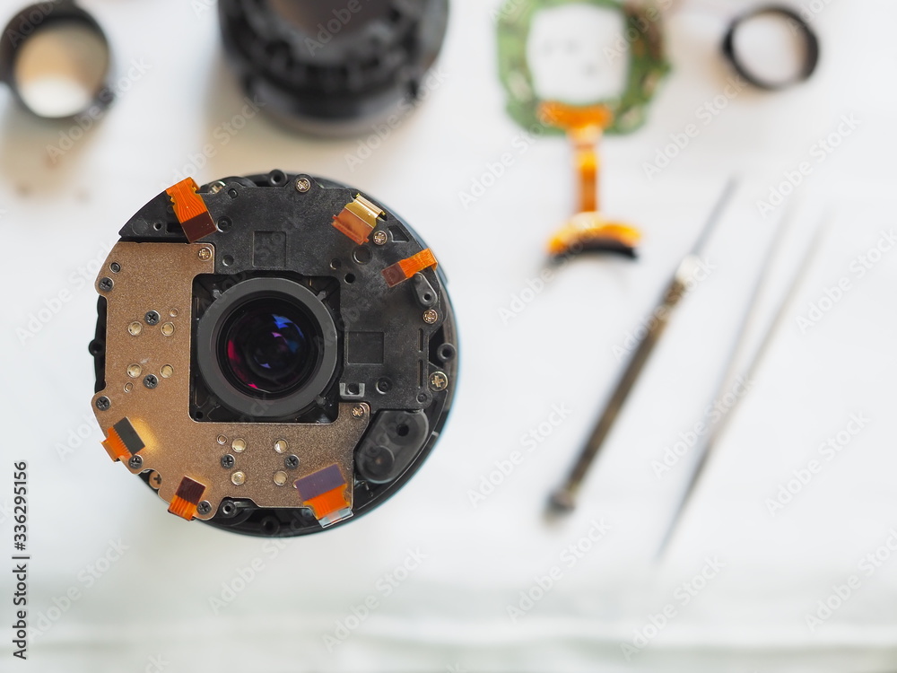 Technician disassembling lens, Disassembly and repair of lens camera by Technician Engineer, Specialist of the center for repair of lens, Selective focus. Technician disassembling lens, Disassembly and repair of lens camera by Technician Engineer, Specialist of the center for repair of lens, Selective focus.