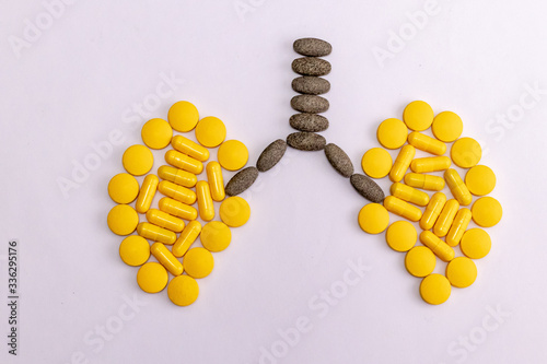 Top view of capsules and tablets making a lung shape on white background. Chest physician concept photo