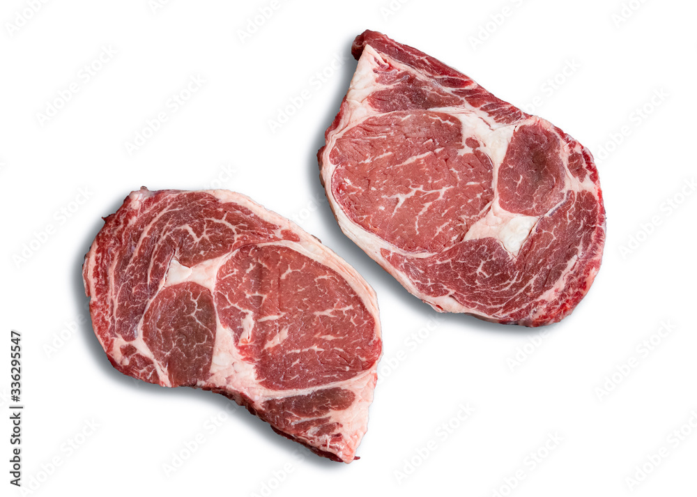 A Couple of Steaks - Two marbled beef steaks are isolated on a white background behind the meat.