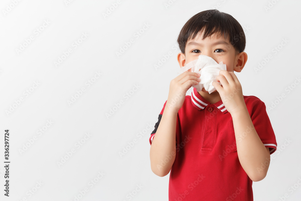 Little asian boy holding a tissue and blow his nose. Kid with cold rhinitis. virus and infection. Coronavirus symptom Little asian boy holding a tissue and blow his nose. Kid with cold rhinitis. virus and infection. Coronavirus symptom