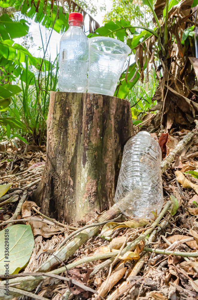 Obraz premium Plastic Bottle And Drinking Glass On Stump