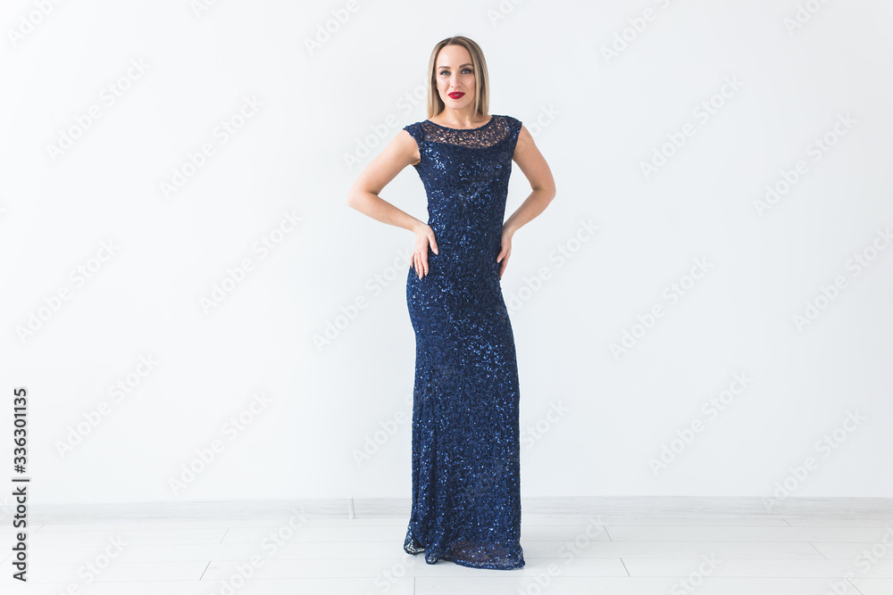 Fashionable young blonde woman in beautiful summer dress posing at white studio. Fashionable young blonde woman in beautiful summer dress posing at white studio.