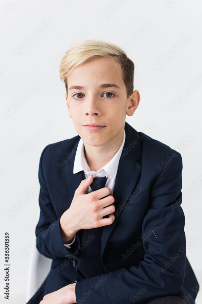 Portrait of stylish school boy teenager in white shirt and jacket against white background with copy space. Portrait of stylish school boy teenager in white shirt and jacket against white background with copy space.