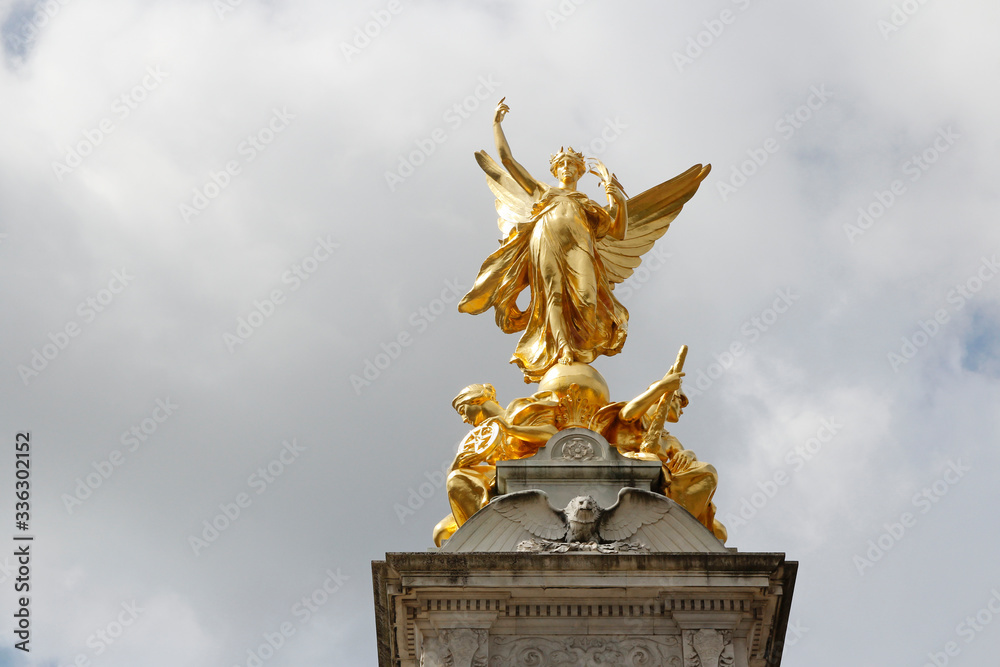 Fototapeta premium Gilded Winged Victory at the top of the Victoria Memorial in front of Buckingham Palace in a sunny day, London, UK